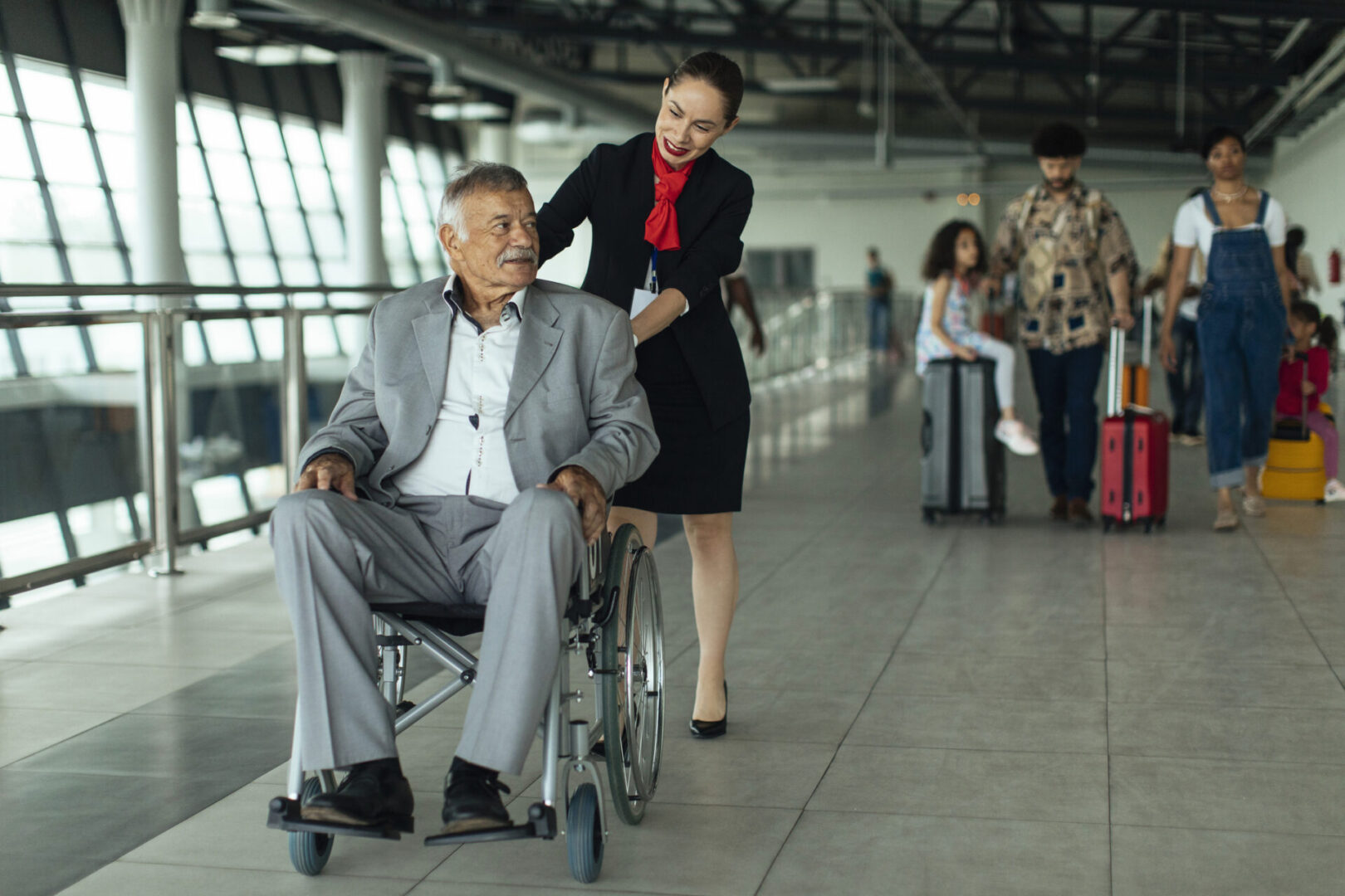 Airport staff assisting man in wheelchair