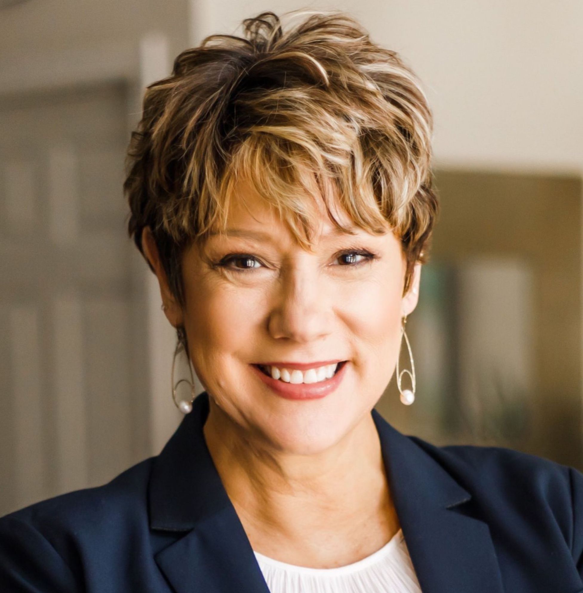 Professional woman with short hair and a warm smile.