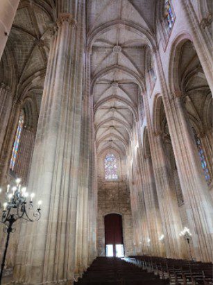 Interior of a grand Gothic cathedral with high vaulted ceilings and tall columns.