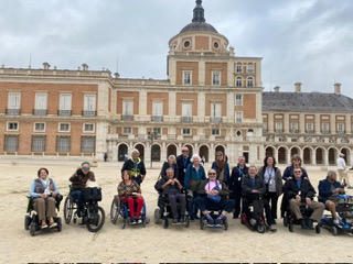 Group photo of people with disabilities outside a historic building.